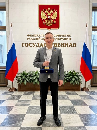 Портрет мужчины с наградой в зале Госдумы РФ