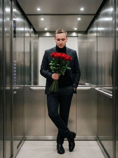 Кинематографичный портрет мужчины с розами в лифте