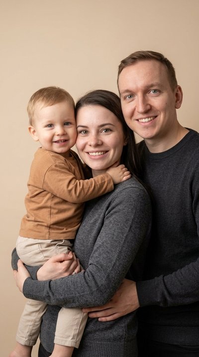 Студийный портрет родителя с ребёнком на бежевом фоне