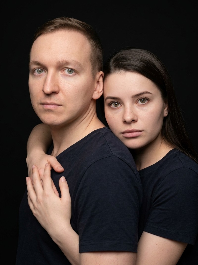 Семейный студийный портрет родителя и ребёнка на чёрном фоне