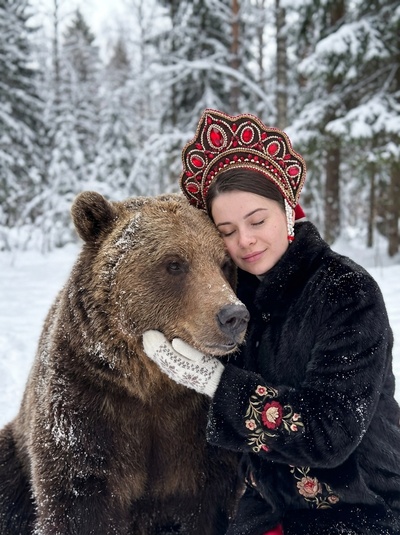 Девушка с медведем в зимнем лесу в кокошнике и шубе
