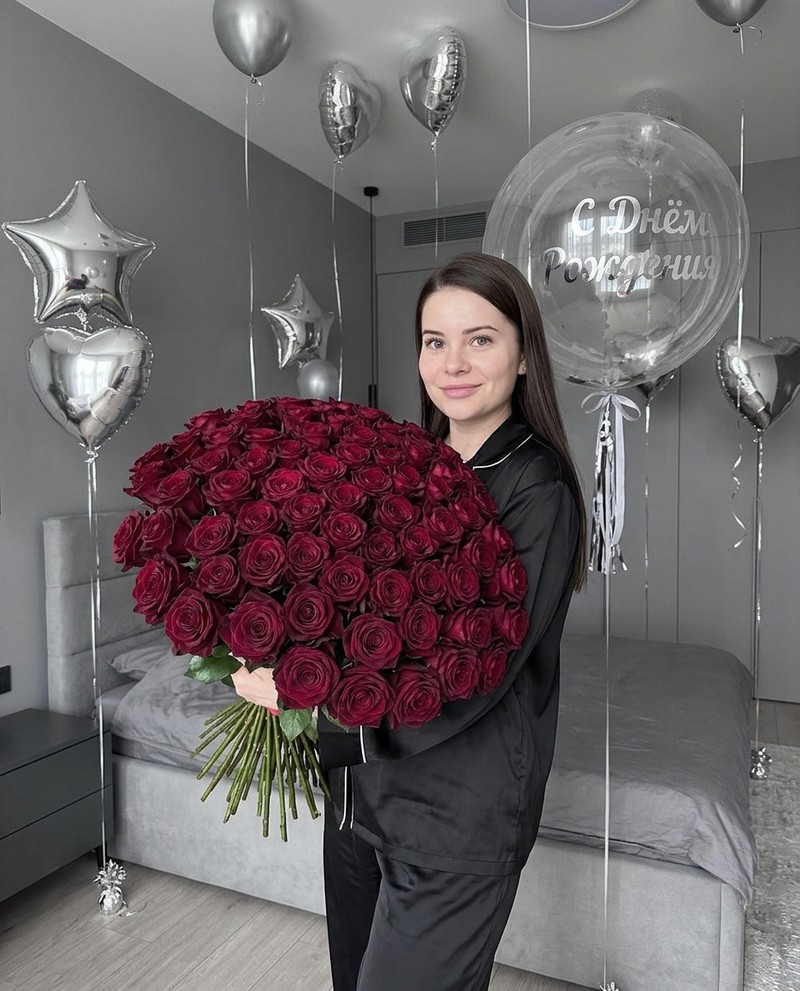 Женщина с букетом роз в минималистской спальне